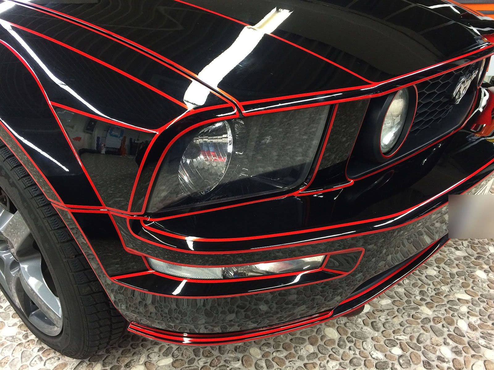 Schwarz folierter Ford Mustang mit rot leuchtenden Tron-Linien